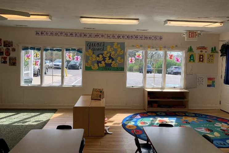 Toddler classroom with child-size furnishings, direct playground access, and cozy window seats.