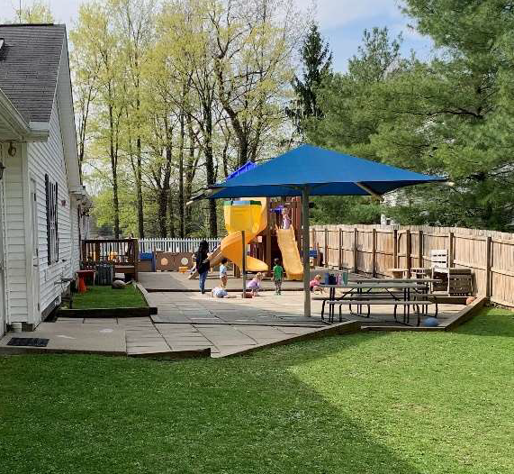 Children playing in the outdoor playground at Young Explorers school on a sunny day