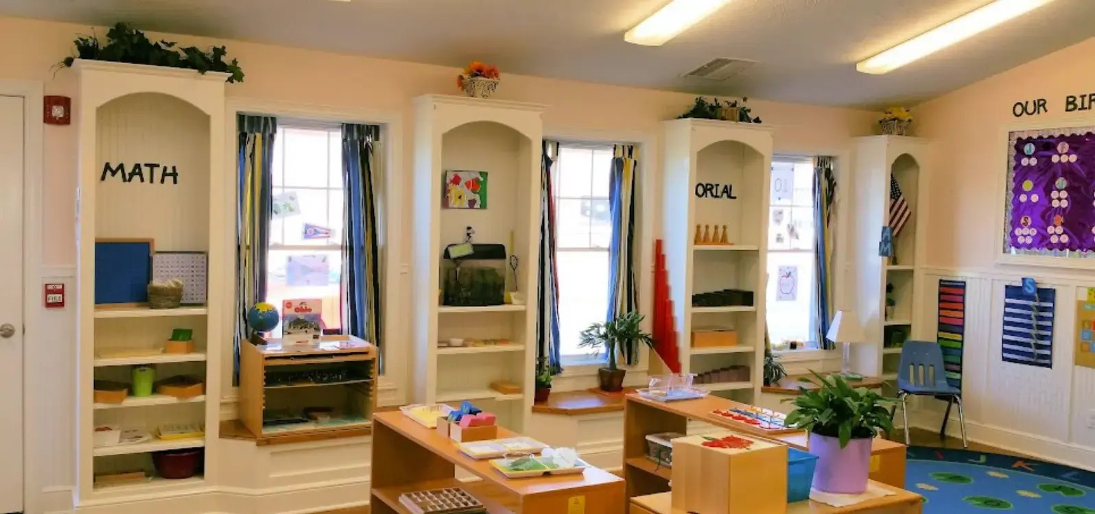 Toddler classroom with child-size furnishings, direct playground access, and cozy window seats.