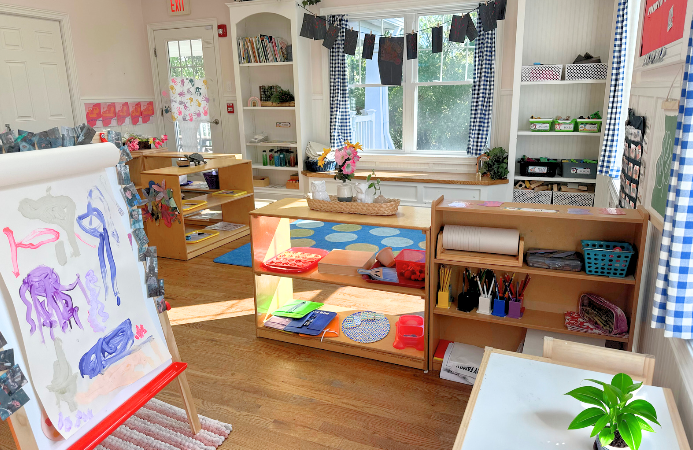 Toddler classroom with child-size furnishings, direct playground access, and cozy window seats.