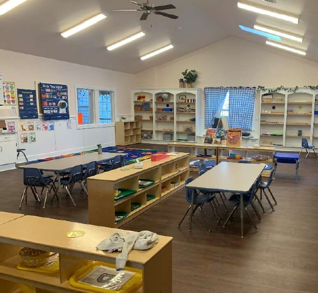 Toddler classroom with child-size furnishings, direct playground access, and cozy window seats.