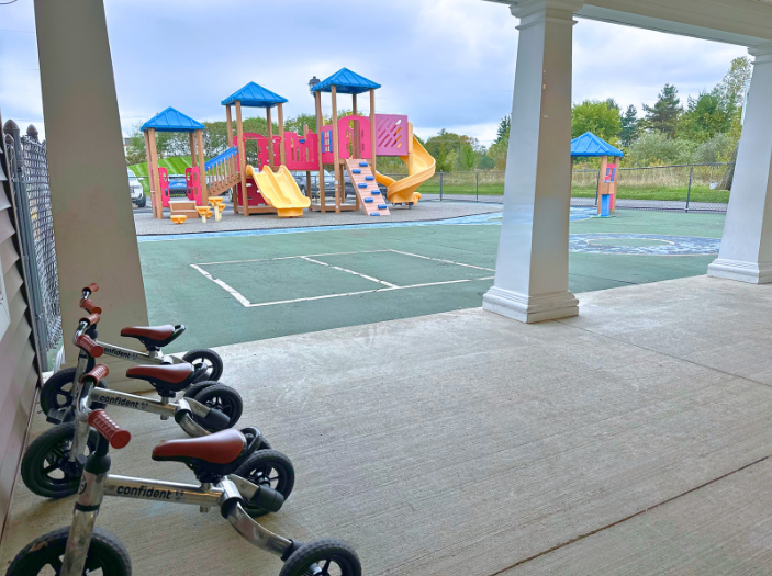 Children playing in the outdoor playground at Young Explorers school on a sunny day